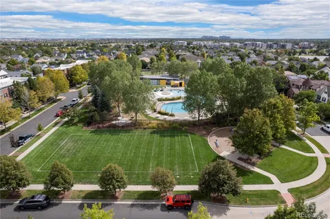 an aerial view of residential houses with outdoor space and trees