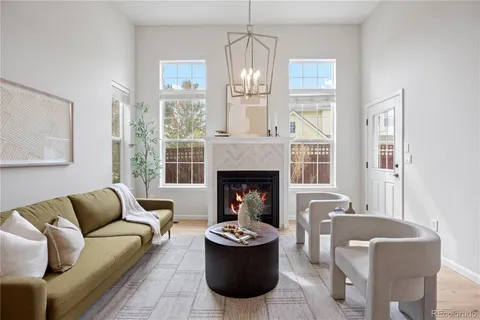 a living room with furniture a fireplace and a chandelier
