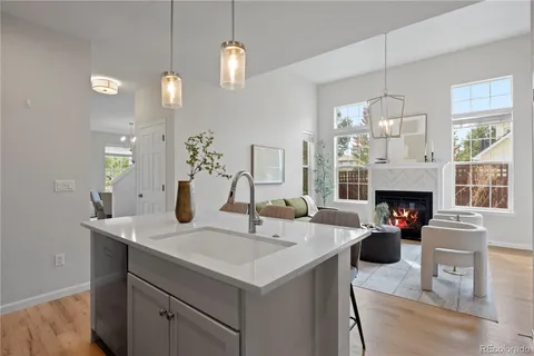 a living room with furniture a fireplace and kitchen view