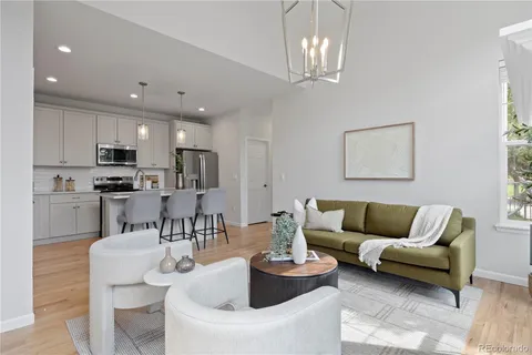 a living room with furniture kitchen and a chandelier
