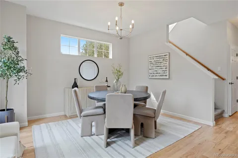 a dining room with furniture a potted plant and wooden floor