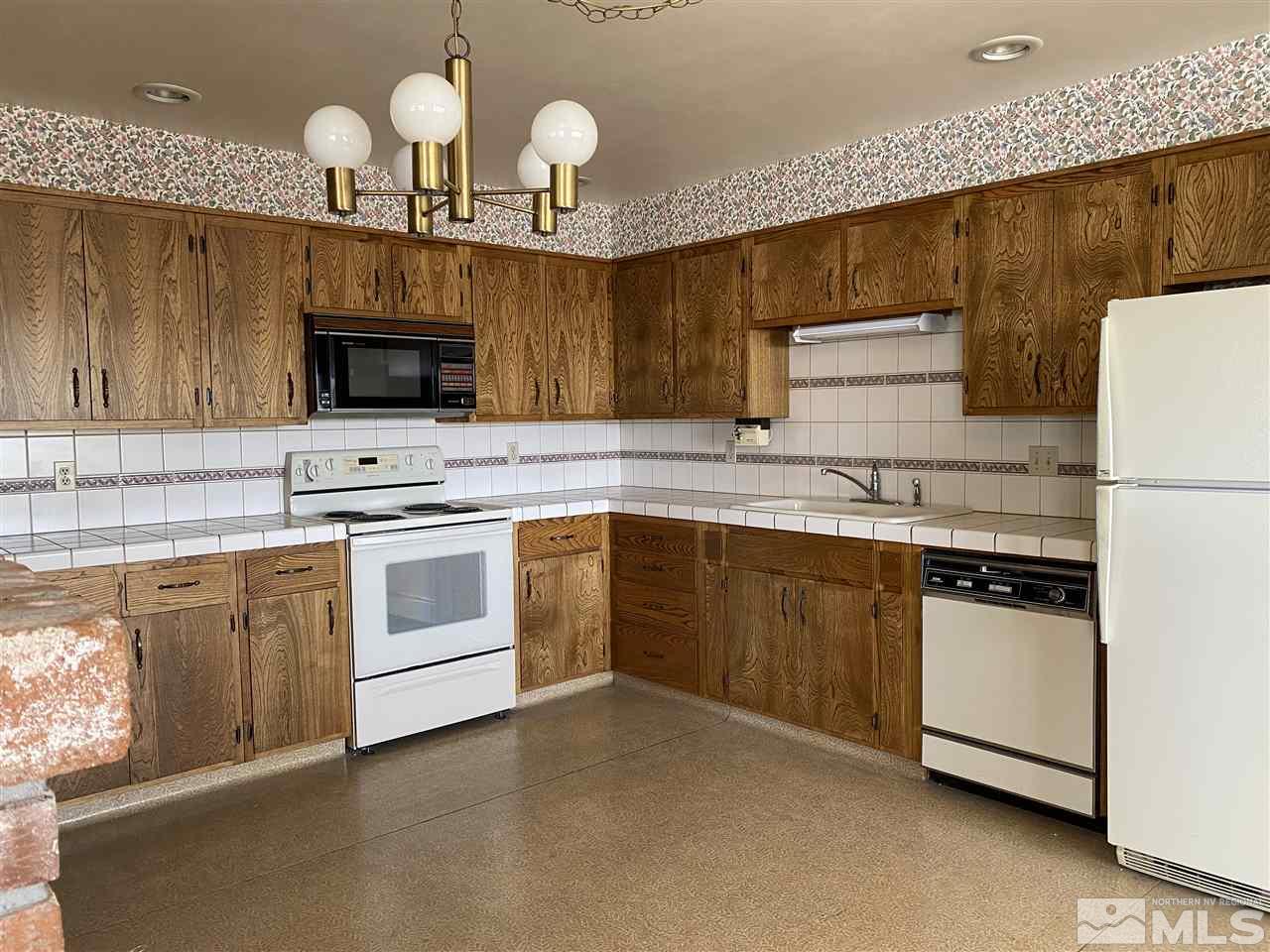 3900 Buckingham Square Reno, NV 89503 - Photo 6 of 35 a kitchen with cabinets stainless steel appliances and wooden floor