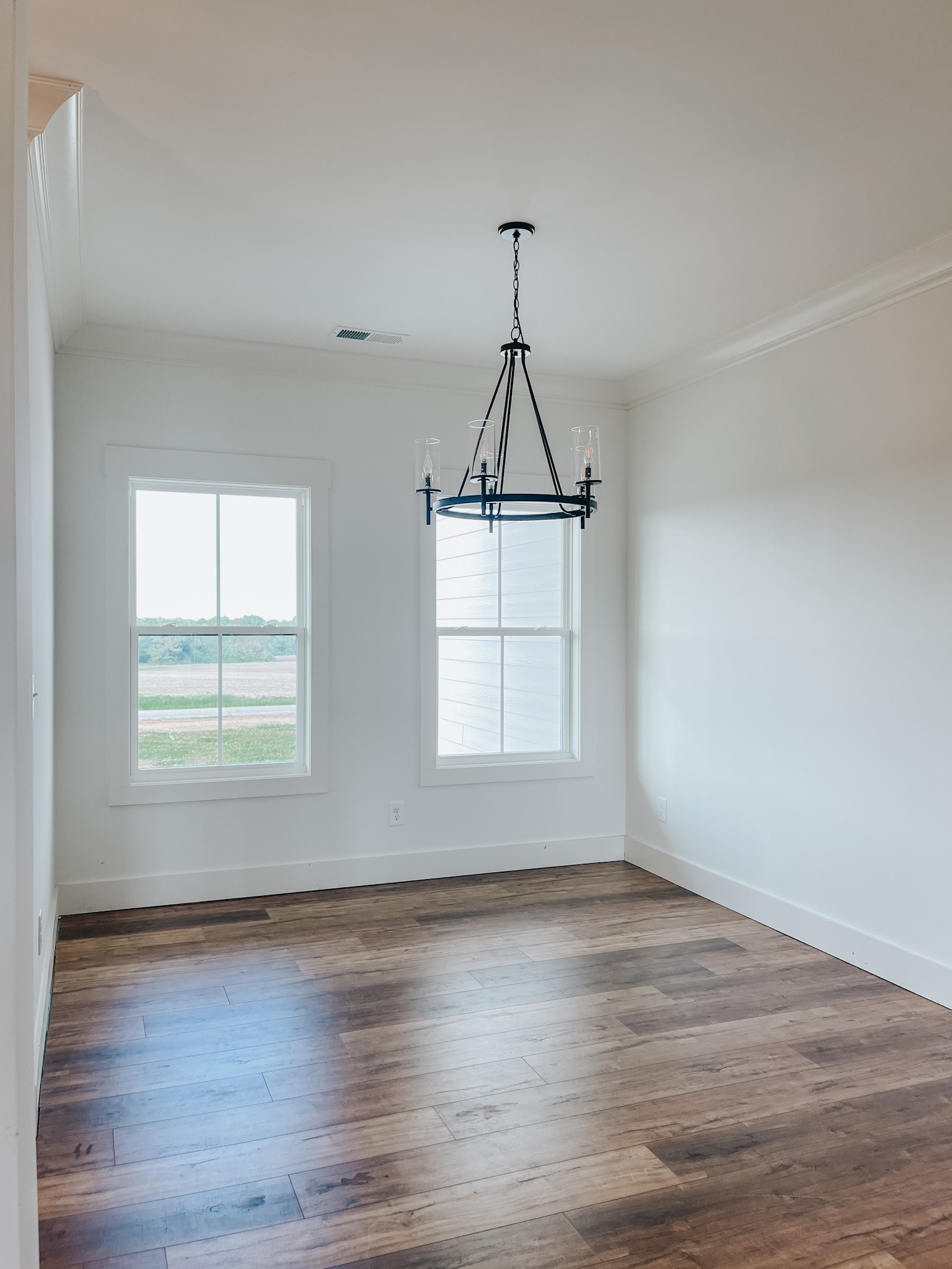 1402 Fowler Ford Road Portland, TN 37148 - Photo 14 of 27 an empty room with wooden floor chandelier and windows
