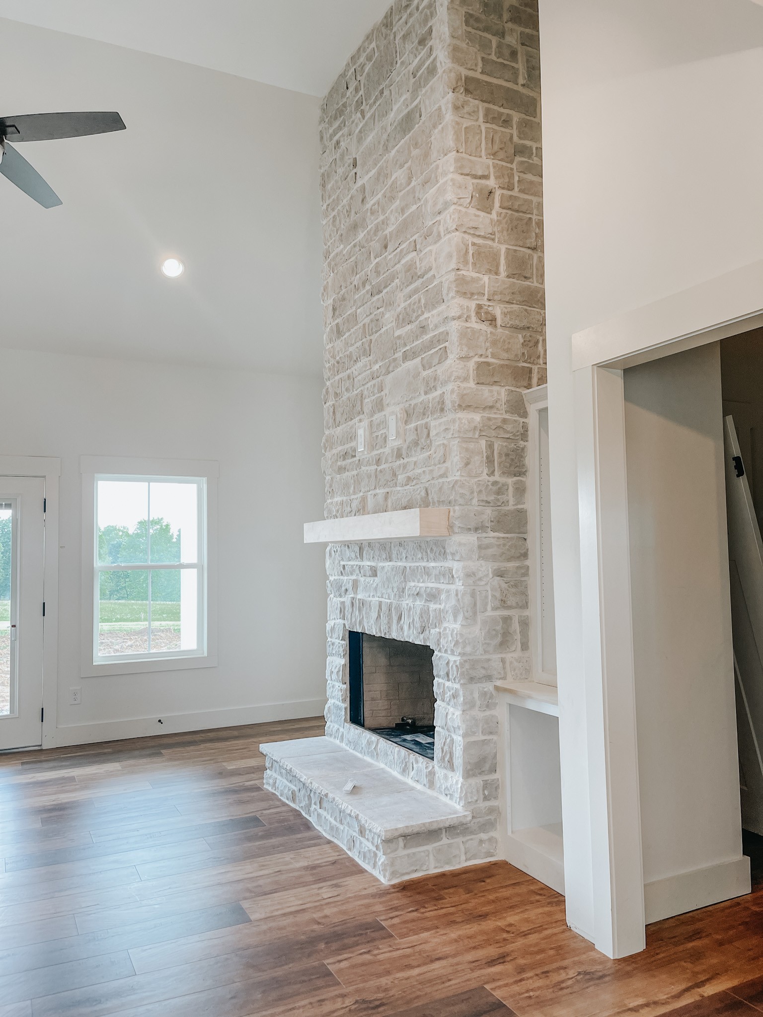 1402 Fowler Ford Road Portland, TN 37148 - Photo 7 of 27 a view of an empty room with wooden floor and a window
