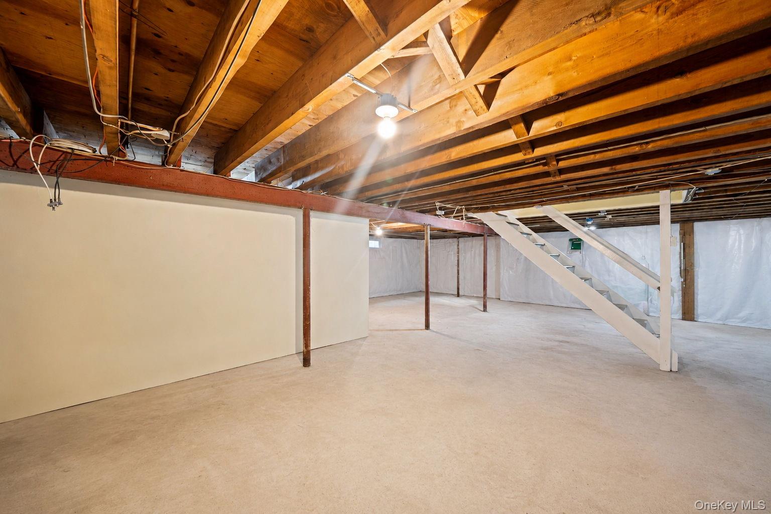 31 Crooked Hill Road Huntington, NY 11743 - Photo 23 of 32 Expansive unfinished basement featuring concrete flooring, exposed wood ceiling joists, and structural support beams