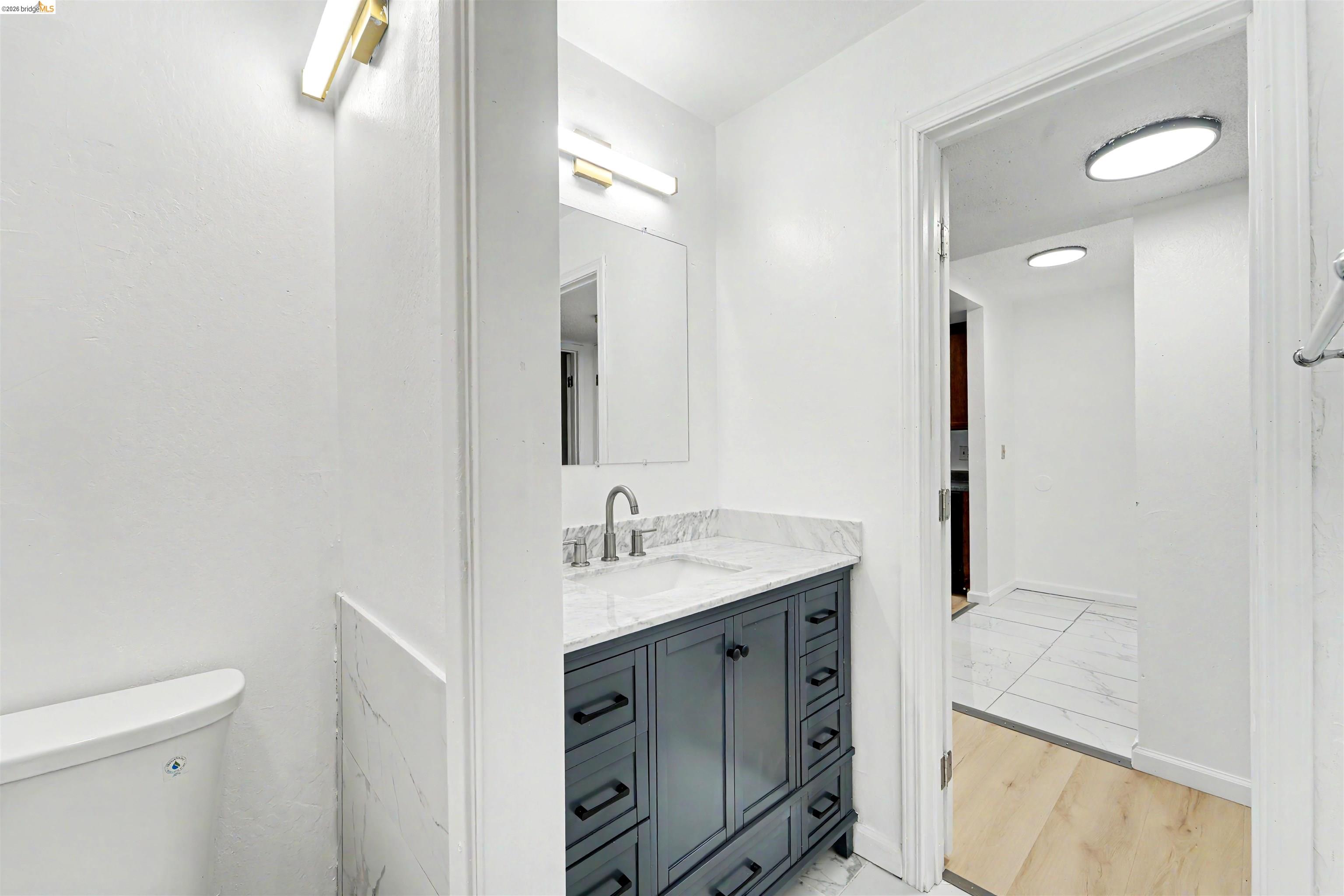 4186 San Pablo Dam Road, Unit A El Sobrante, CA 94803 - Photo 15 of 34 Bathroom featuring a dark wood-finish vanity with ample storage, a white countertop with integrated sink, and a brushed nickel faucet