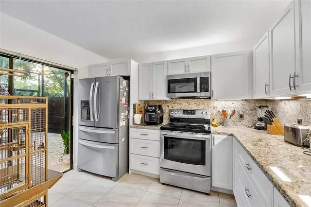 a kitchen with stainless steel appliances granite countertop a stove a refrigerator and a stove top oven