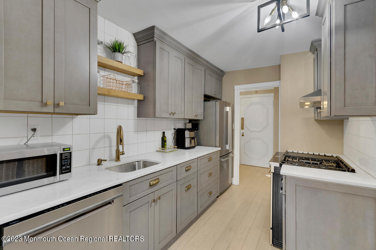 28 Riverside Avenue, Unit 4J Red Bank, NJ 07701 - Photo 2 of 18 a kitchen with stainless steel appliances a sink stove and cabinets