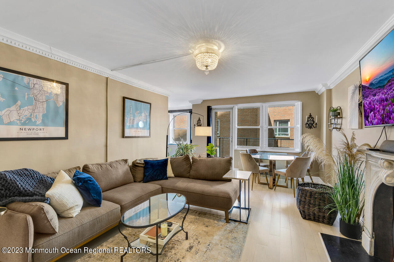 28 Riverside Avenue, Unit 4J Red Bank, NJ 07701 - Photo 5 of 18 a living room with furniture a fireplace and a flat screen tv