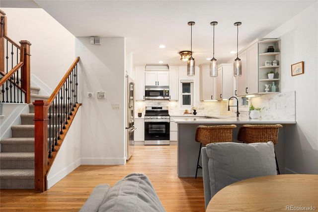 a kitchen with white cabinets and stainless steel appliances