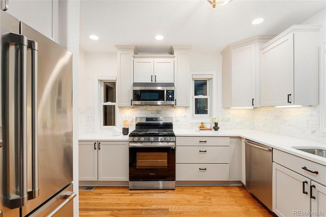 a kitchen with white cabinets stainless steel appliances and sink