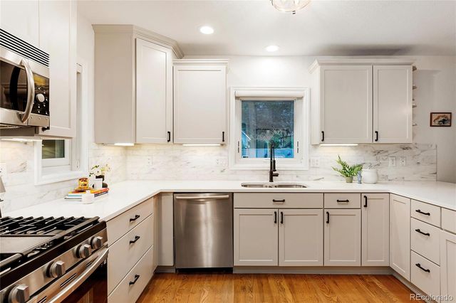 a kitchen with kitchen island granite countertop a stove top oven a sink and a granite counter tops