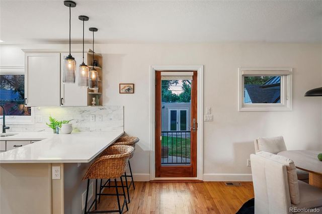 a kitchen with stainless steel appliances kitchen island granite countertop a table chairs and a refrigerator