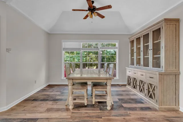 a dining room with wooden floor and a rug