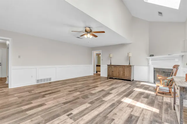 a view of a livingroom with an empty space & a ceiling fan