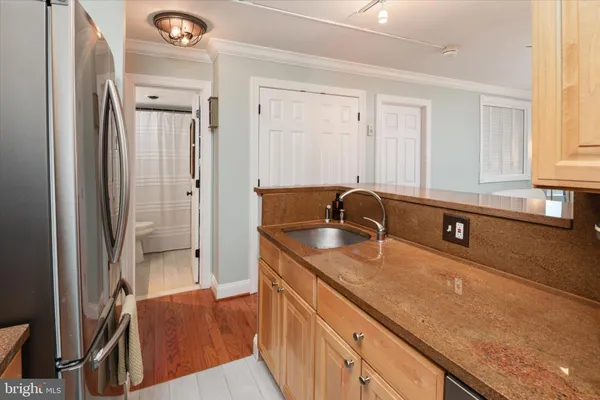 a kitchen with granite countertop a sink and a refrigerator