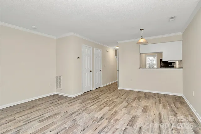 a view of empty room with wooden floor