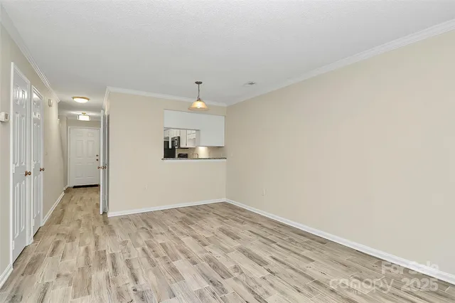 a view of a kitchen with wooden floor and white doors