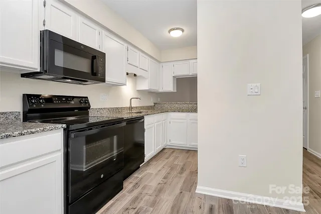 a kitchen with stainless steel appliances a stove microwave and sink