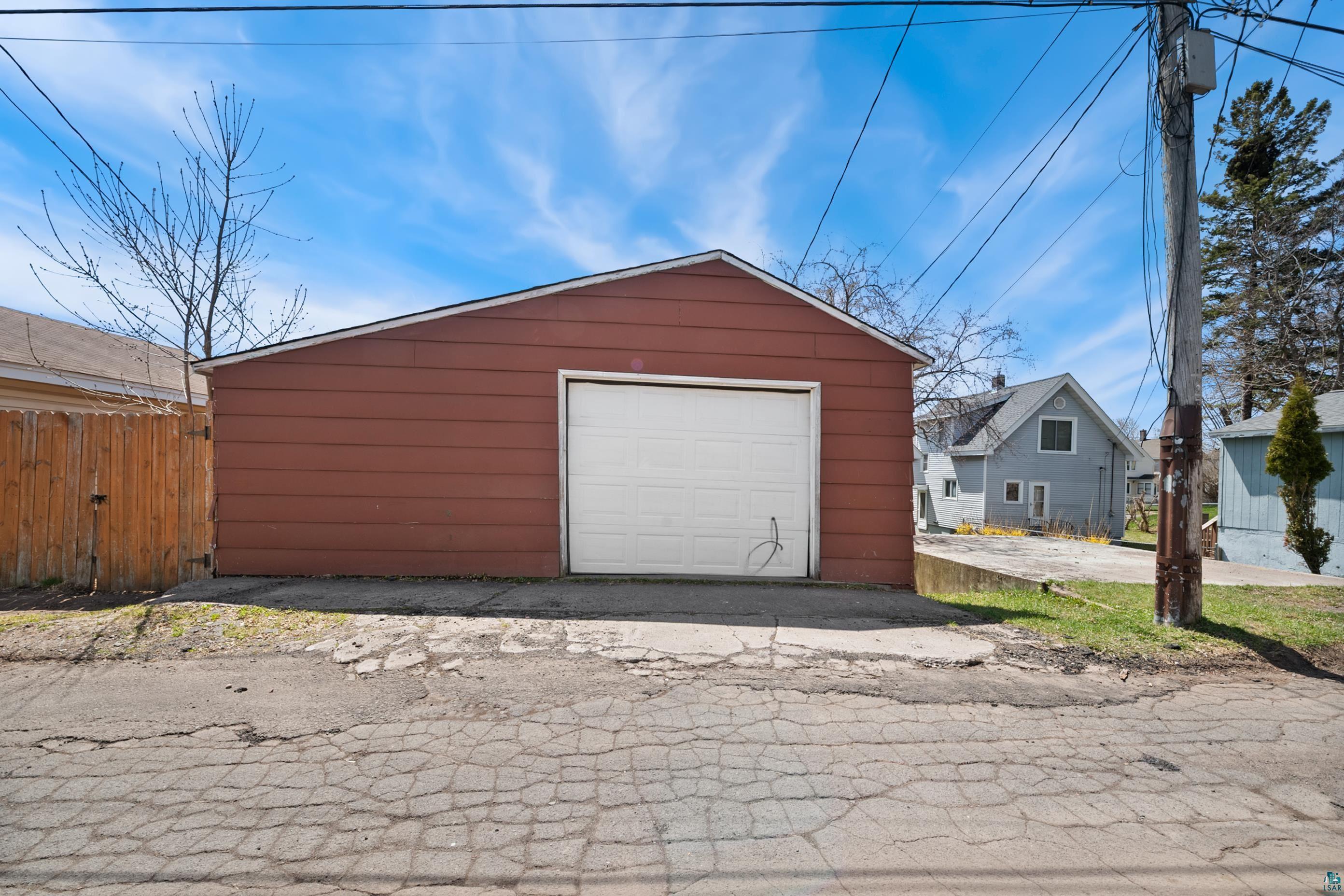 3067 Restormel Street Duluth, MN 55806 - Photo 21 of 25 Detached garage with red horizontal siding and a white panel garage door