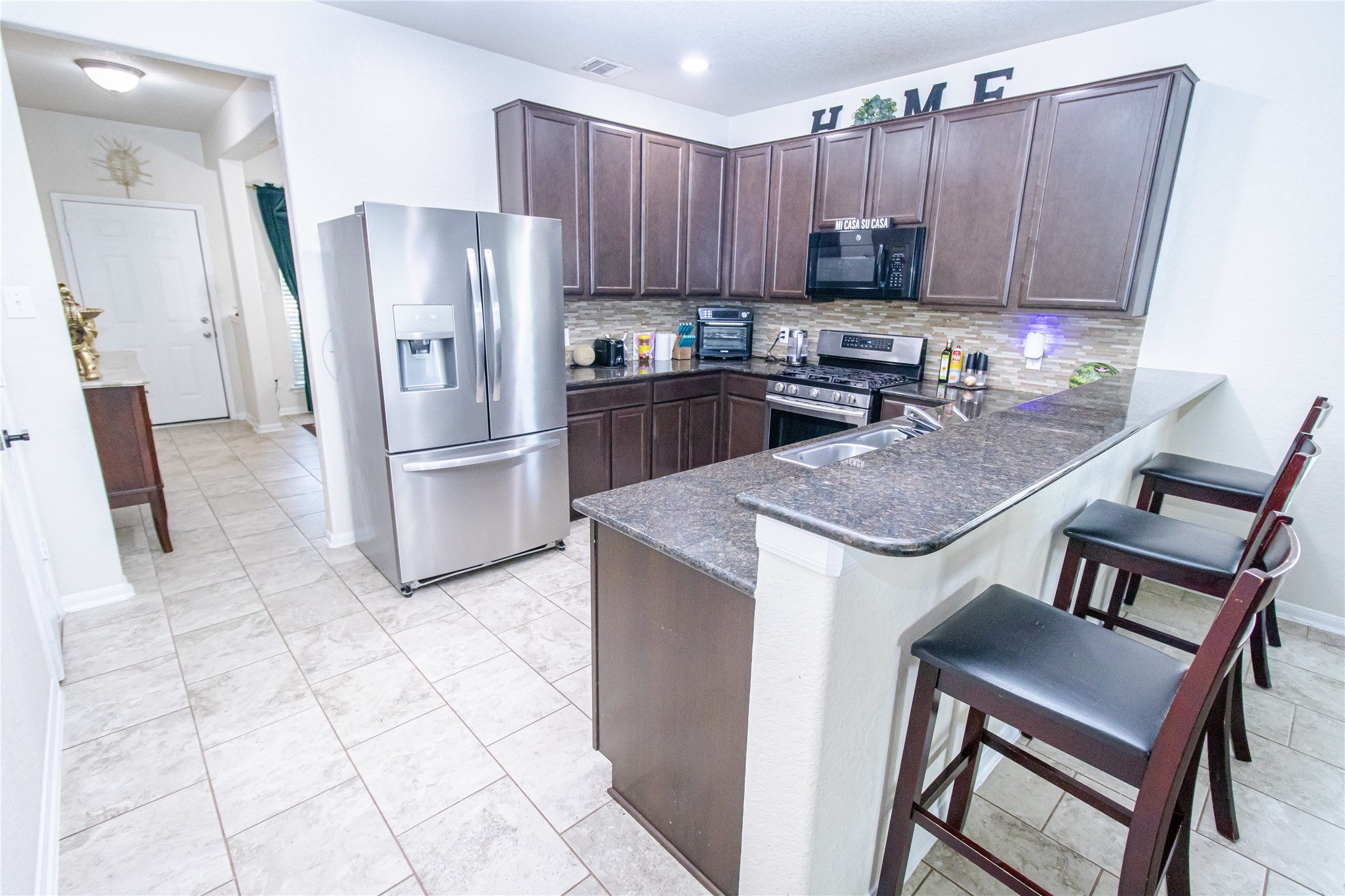 8222 Pastel Dawn Trace Houston, TX 77049 - Photo 4 of 35 a kitchen with a stove a refrigerator and a cabinets