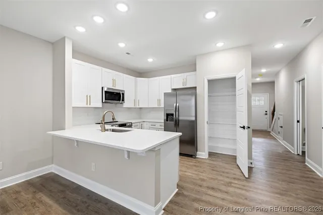 a kitchen with refrigerator and cabinets