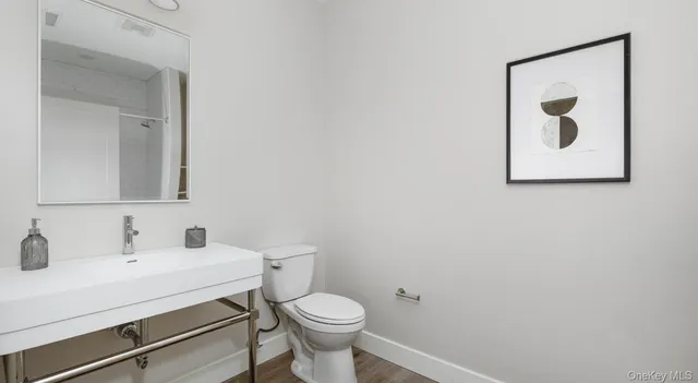 a bathroom with a toilet sink and mirror