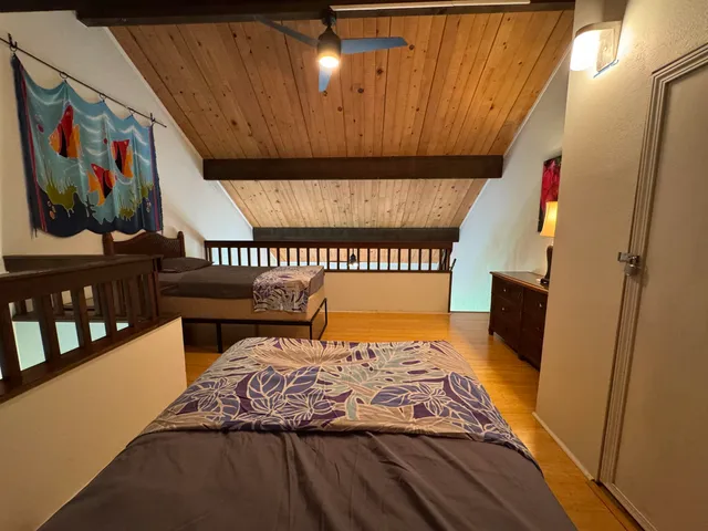 a bedroom with bed and wooden floor