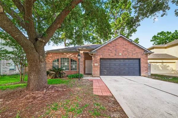 front view of a house with a yard and an trees