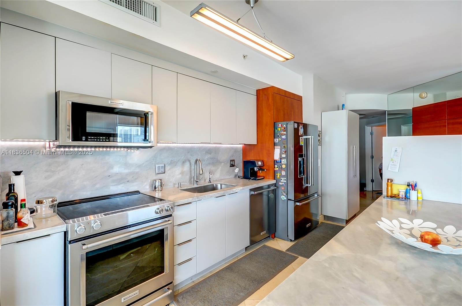 3131 Northeast 188th Street, Unit 1808 Aventura, FL 33180 - Photo 11 of 72 a kitchen with stainless steel appliances a stove microwave and a sink