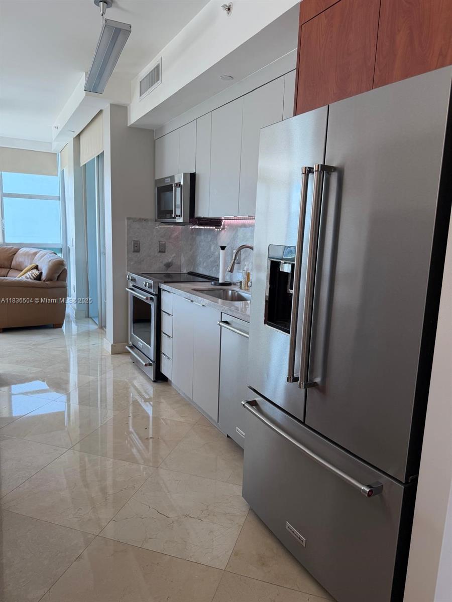 3131 Northeast 188th Street, Unit 1808 Aventura, FL 33180 - Photo 13 of 72 a kitchen with stainless steel appliances a refrigerator sink and stove