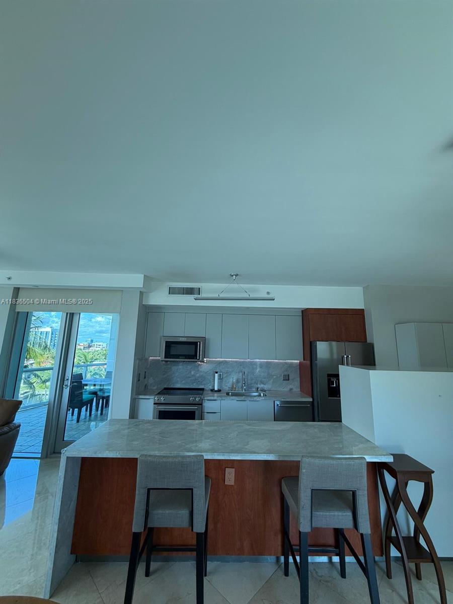 3131 Northeast 188th Street, Unit 1808 Aventura, FL 33180 - Photo 14 of 72 a living room with stainless steel appliances kitchen island granite countertop furniture and a fireplace