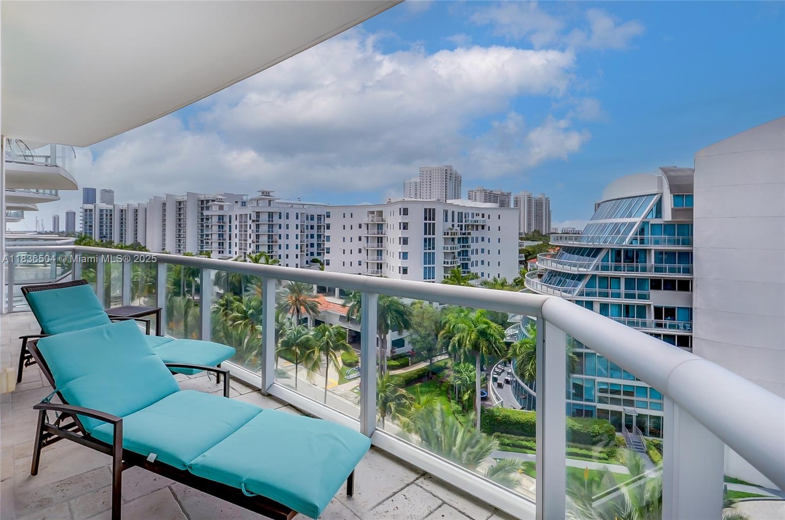 3131 Northeast 188th Street, Unit 1808 Aventura, FL 33180 - Photo 20 of 72 a view of a city from a balcony with furniture