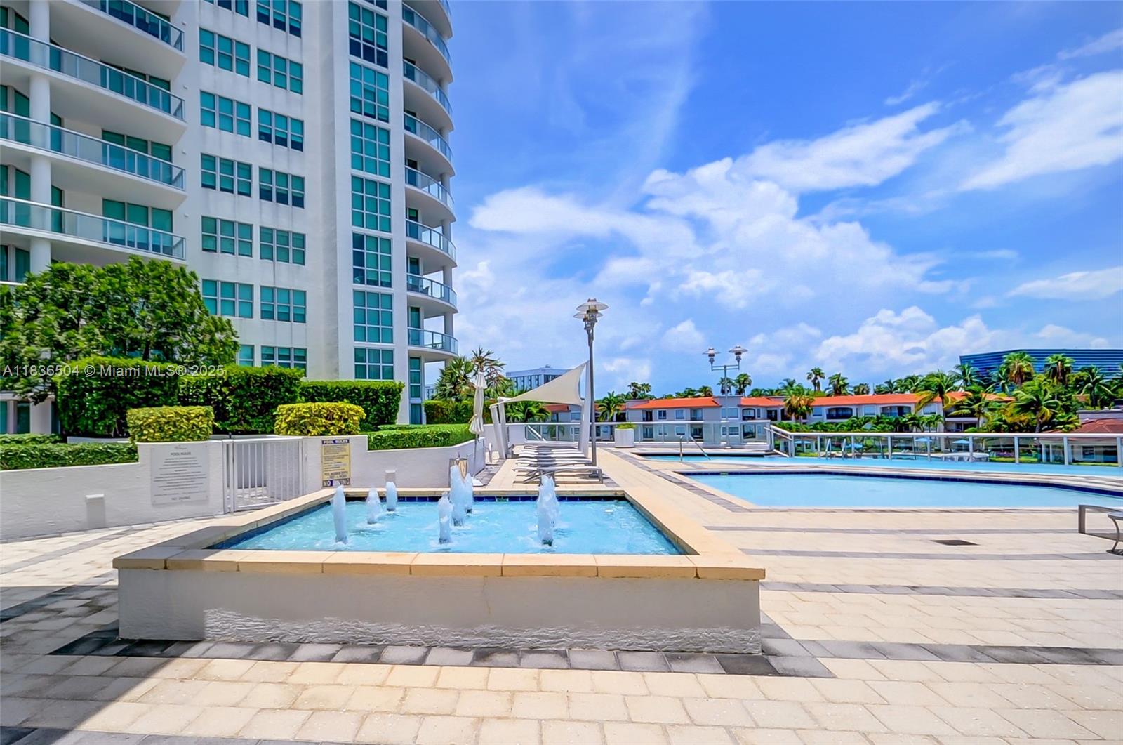 3131 Northeast 188th Street, Unit 1808 Aventura, FL 33180 - Photo 63 of 72 a view of a patio with swimming pool and table and chairs