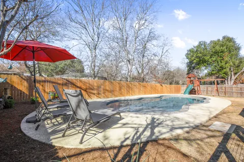 a view of a backyard with swimming pool