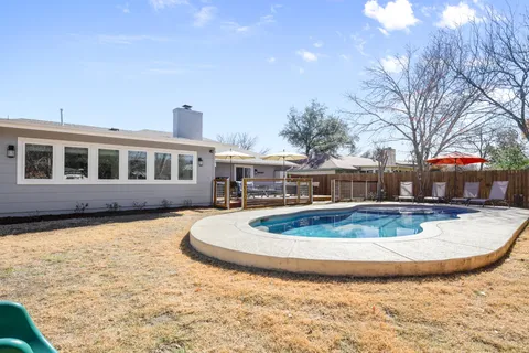 a view of a house with swimming pool and sitting area