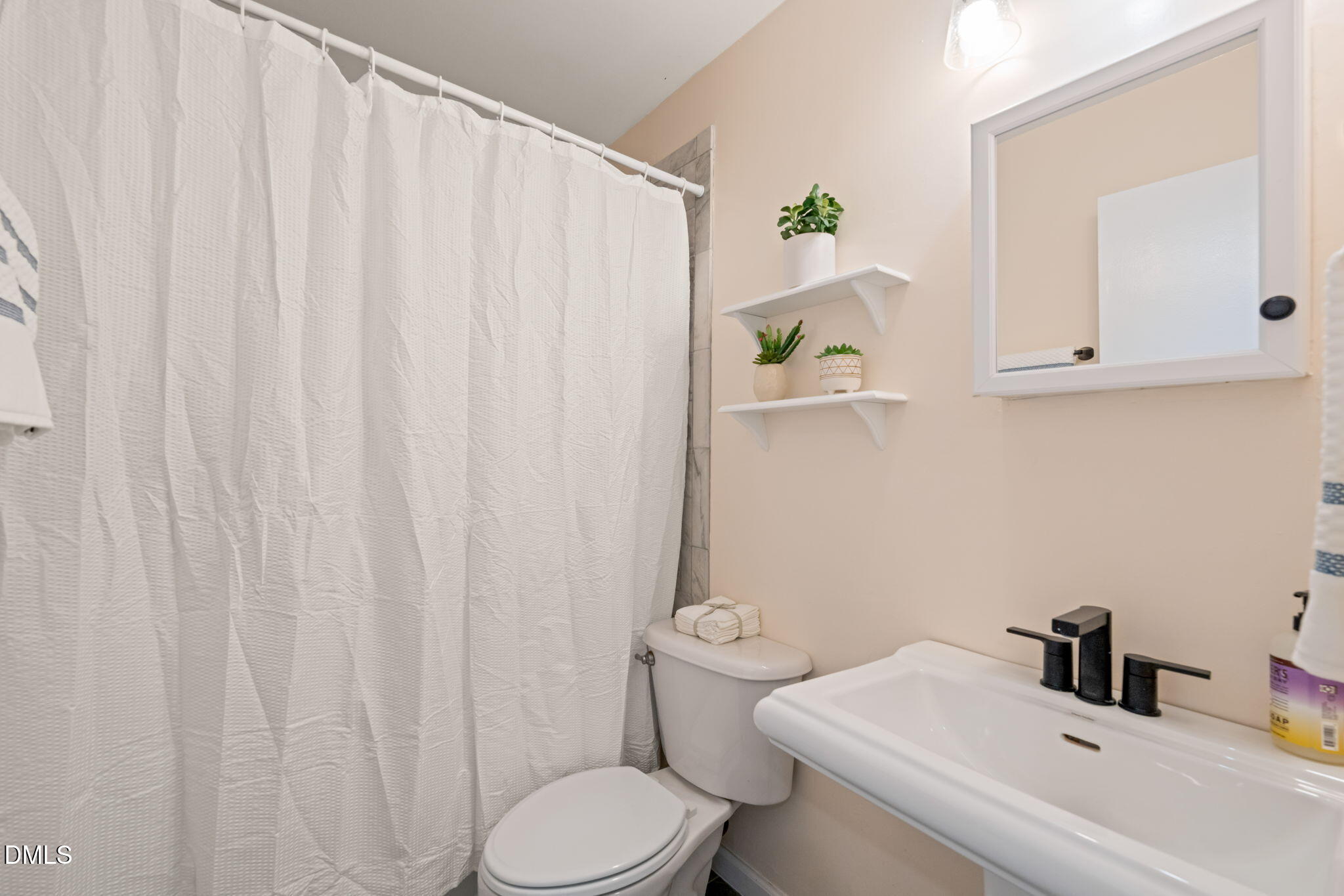 1004 Woodhill Court Raleigh, NC 27615 - Photo 24 of 43 a bathroom with a sink a toilet and a mirror