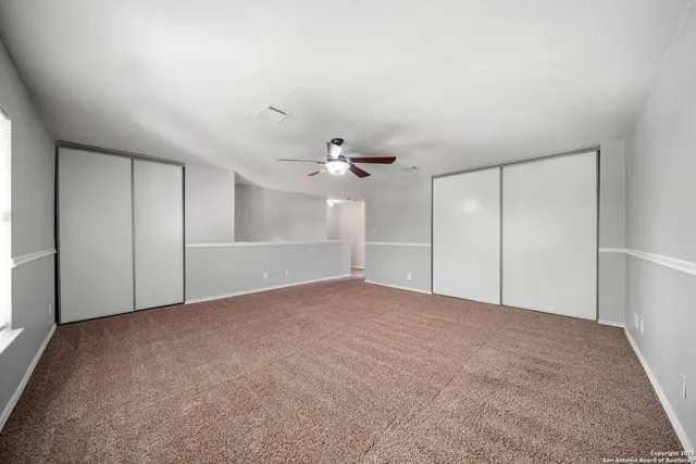 a view of an empty room with a ceiling fan