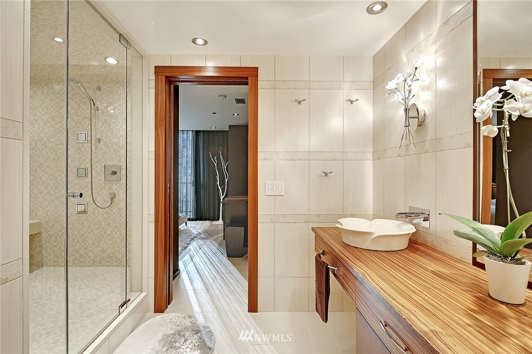 177 107th Avenue Northeast, Unit 1202 Bellevue, WA 98004 - Photo 17 of 25 a en suite bathroom with a granite countertop sink and a mirror