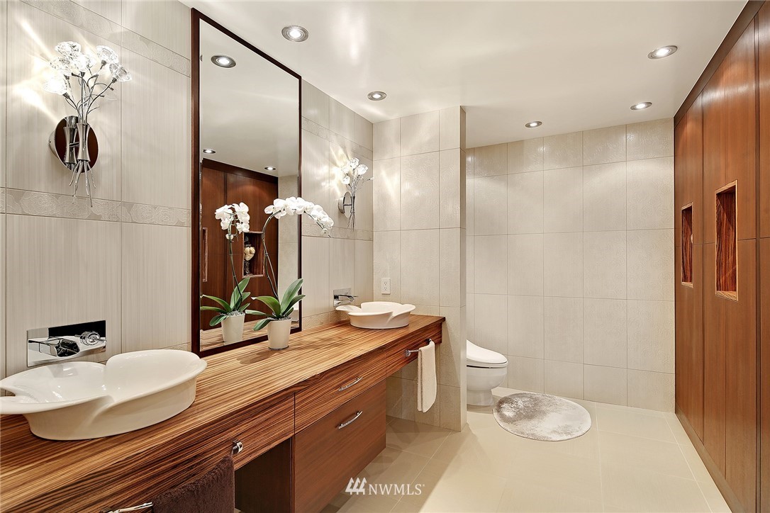 177 107th Avenue Northeast, Unit 1202 Bellevue, WA 98004 - Photo 18 of 25 a bathroom with a double vanity sink toilet and a mirror