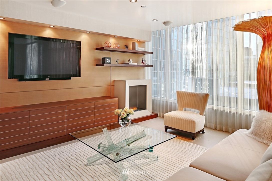 177 107th Avenue Northeast, Unit 1202 Bellevue, WA 98004 - Photo 3 of 25 a bedroom with furniture and a fireplace