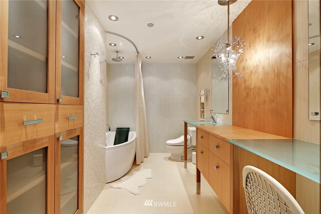 177 107th Avenue Northeast, Unit 1202 Bellevue, WA 98004 - Photo 21 of 25 a bathroom with a double vanity sink a mirror a bathtub and shower