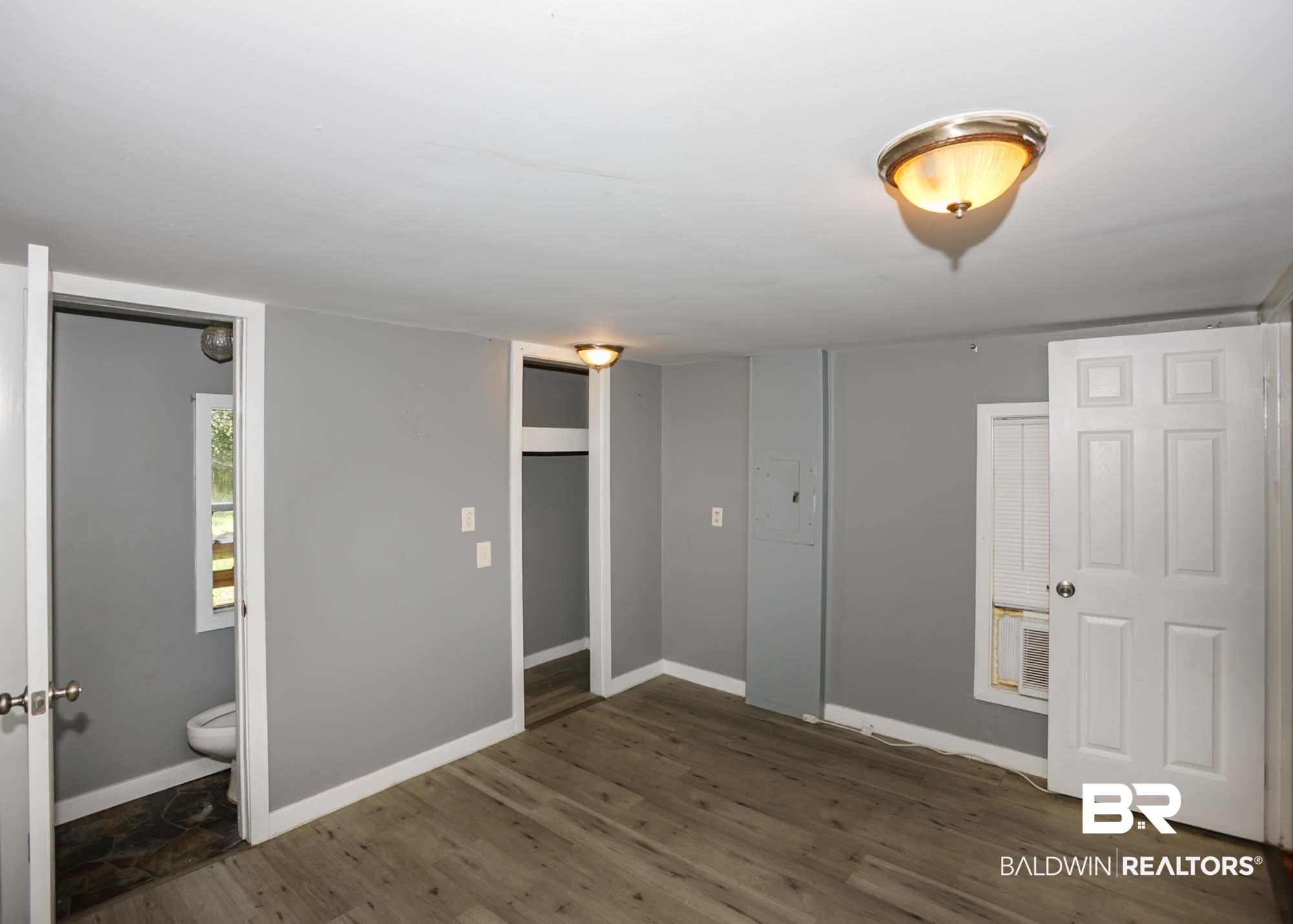 11998 Workman Avenue Foley, AL 36535 - Photo 46 of 59 Unfurnished bedroom featuring wood finished floors and ensuite bathroom