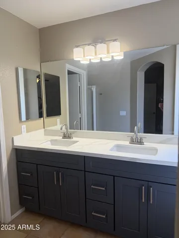 a bathroom with a double vanity sink and a mirror