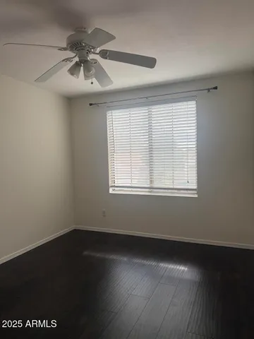 en empty room with wooden floor and windows