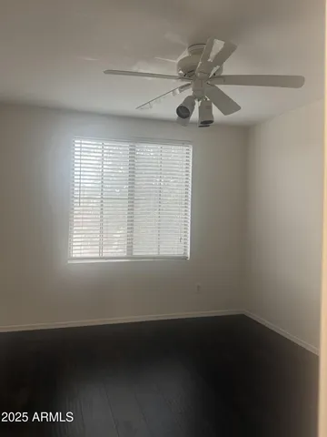 an empty room with a window and a fan