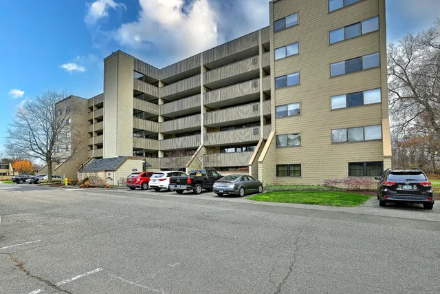 a view of building with cars parked in front of it