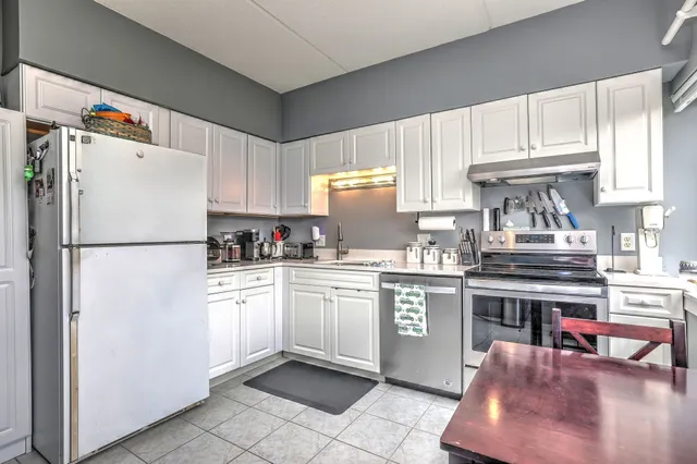 a kitchen with stainless steel appliances granite countertop a refrigerator sink and stove