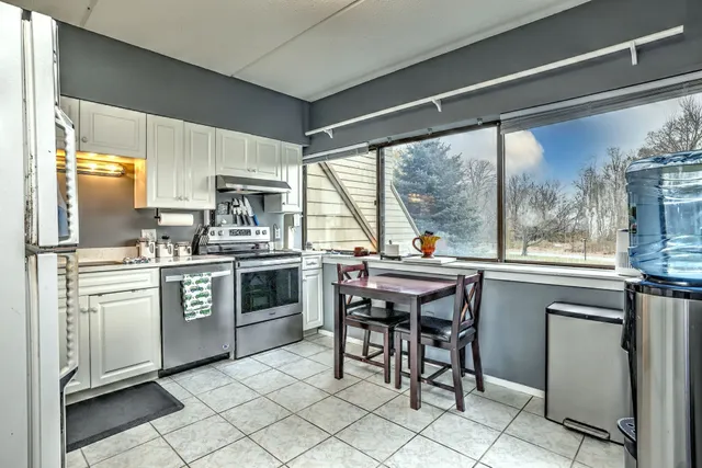 a kitchen with a stove a sink a oven a dining table and chairs