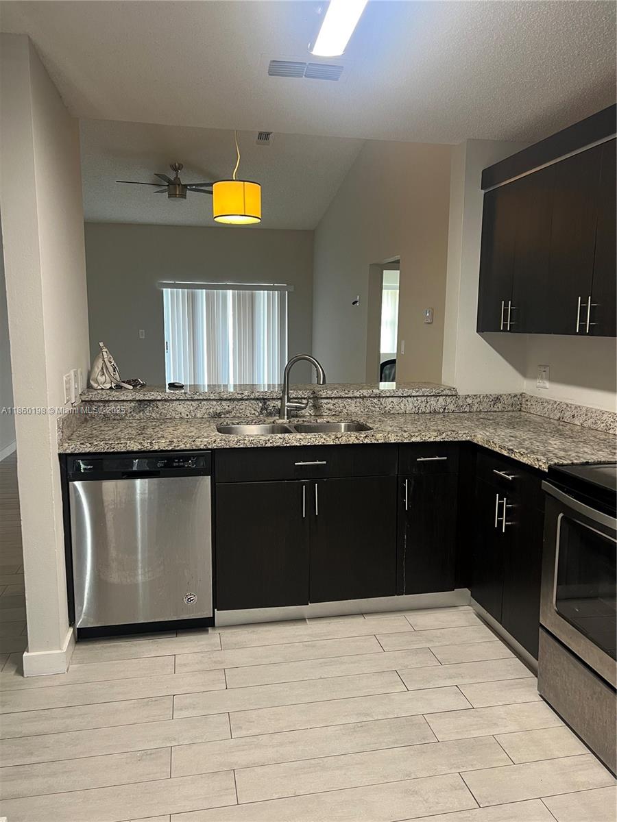 2228 Southwest 80th Terrace, Unit 2228 Miramar, FL 33025 - Photo 15 of 18 a kitchen with a sink a counter top space cabinets and stainless steel appliances